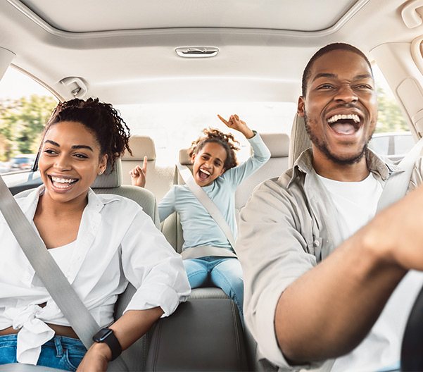 Happy family driving car with child in the back