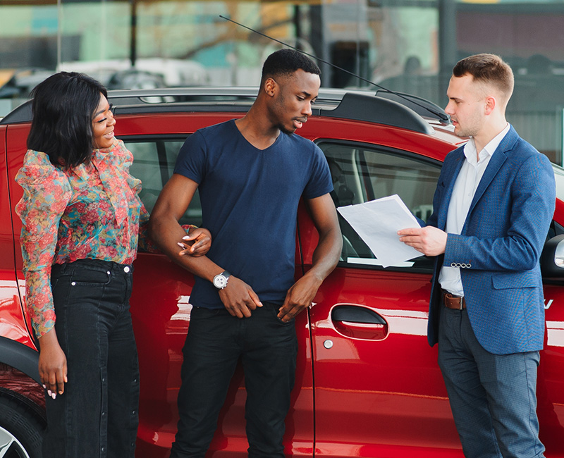 Couple talking with car salesman